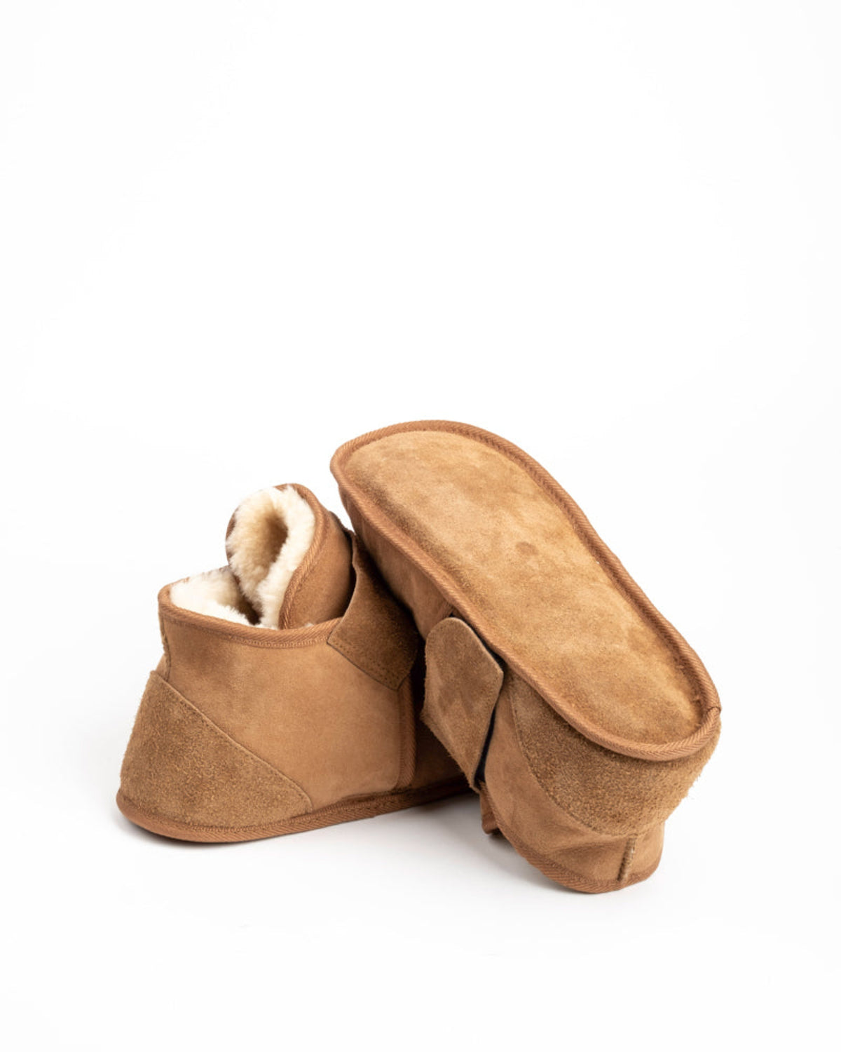 Pair of brown suede slippers on a white background